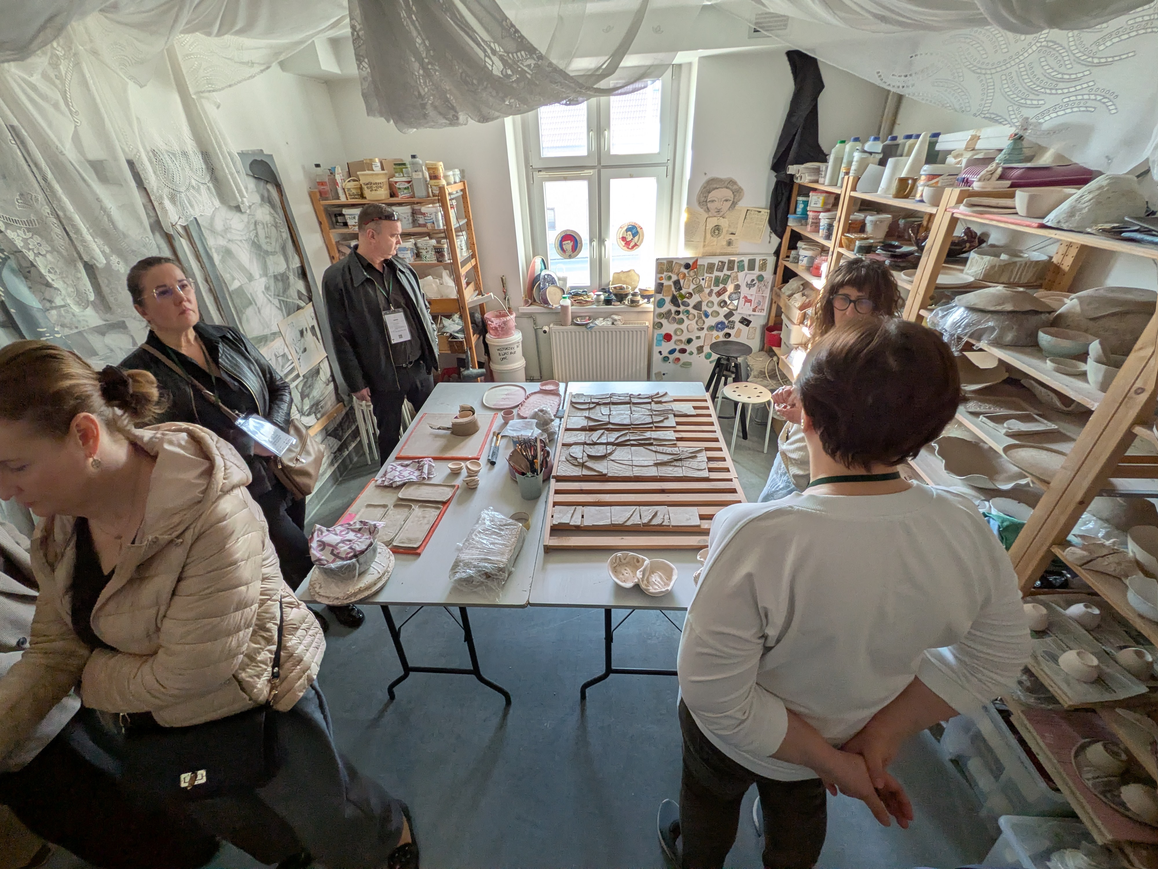 Fotografia przedstawia grupę ludzi w pracowni ceramiki.