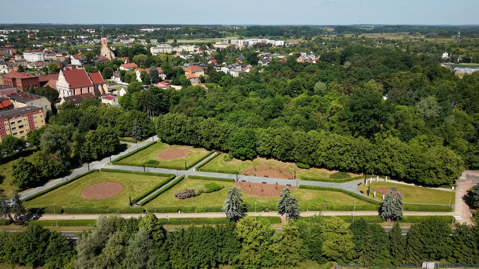 Widok z drona na park kieszonkowy Ogórd Róż z widocznymi obszarami nasadzeń w kształcie koła i dwoma