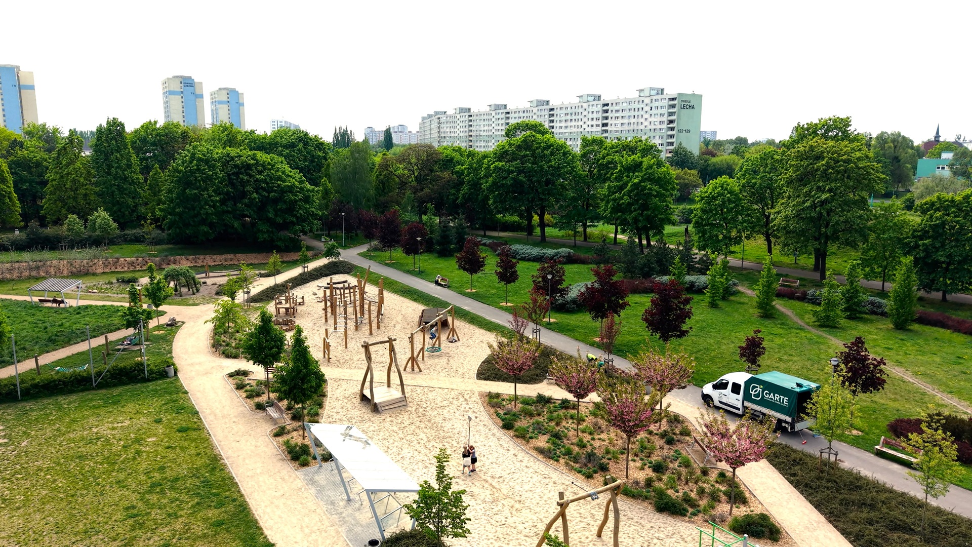 Widok z drona na zmodernizowaną część parku na Chartowie - na pierwszym planie plac zabaw i drzewa,
