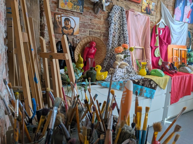 Widok wnętrza pracowni malarskiej - na pierwszym tle pojemnik na pędzle