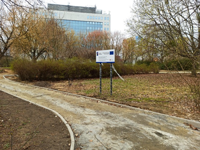 Widok budowanej ścieżki w Parku Czarneckiego, na pierwszym planie tablica informacyjna.