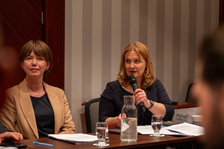 Zdjęcie przedstawia dwie kobiety, jedna z nich trzyma w ręce mikrofon.