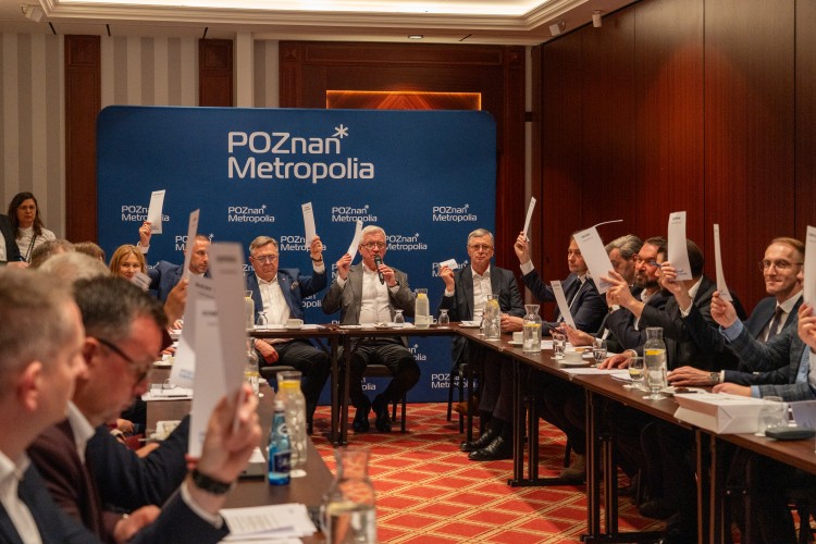 Zdjęcie przedstawia ludzi podnoszących do góry kartki papieru.