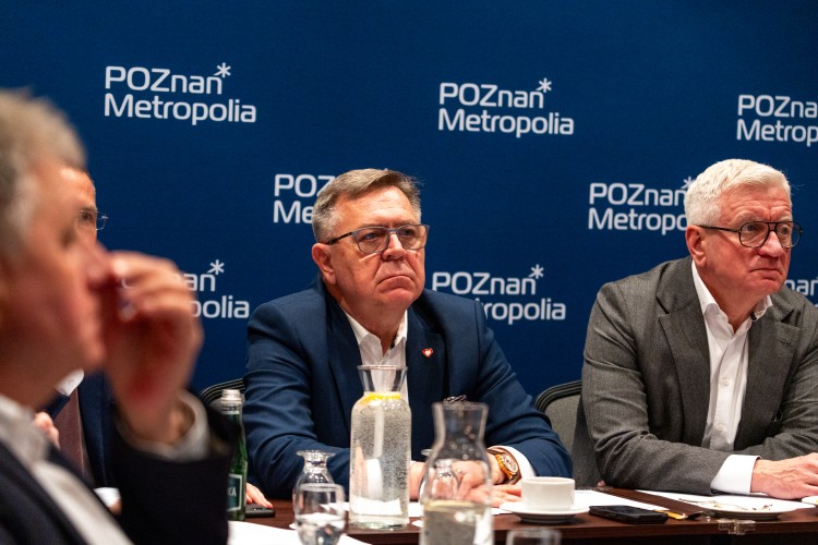 Zdjęcie przedstawia dwóch mężczyzn siedzących przy stole.