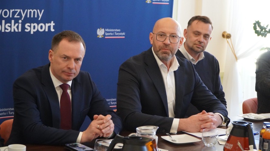 Zdjęcie przedstawia trzech mężczyzn. Na środku widoczny Minister Sportu i Turystyki.