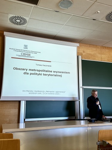 Zdjęcie przedstawia przemawiającego mężczyznę w sali (profesor).