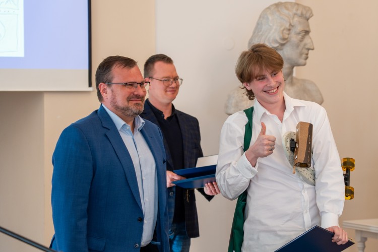 Zdjęcie przedstawia chłopaka, który jest laureatem konkursu, po wręczeniu nagrody.