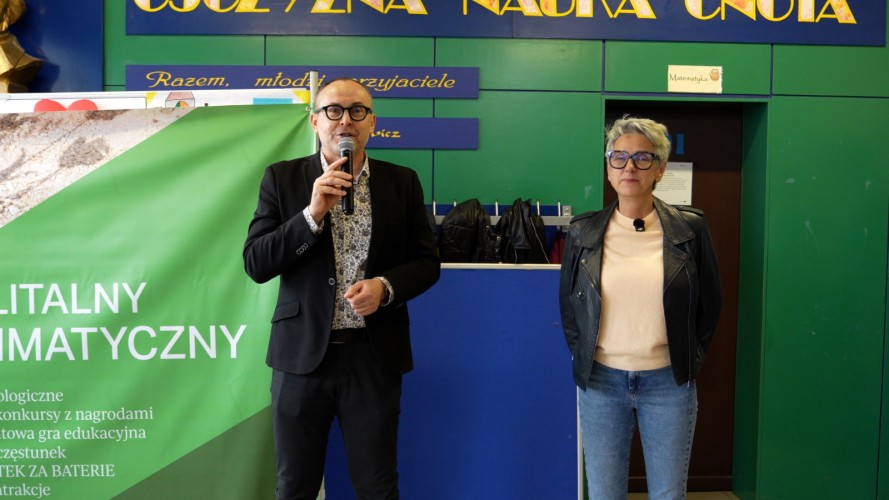 Dwie osoby w budynku - jedna z nich przemawia przez mikrofon