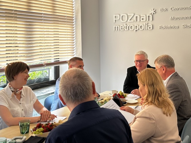 Zdjęcie przedstawia kilka osób siedzących przy stole podczas posiedzenia Zarządu Metropolii Poznań.