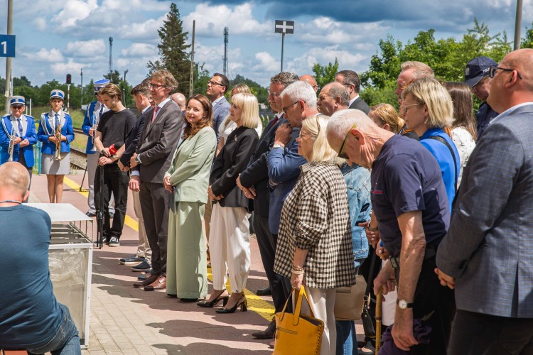 Zdjęcie przedstawia osoby uczestniczące w uroczystym otwarciu nowego budynku dworca.