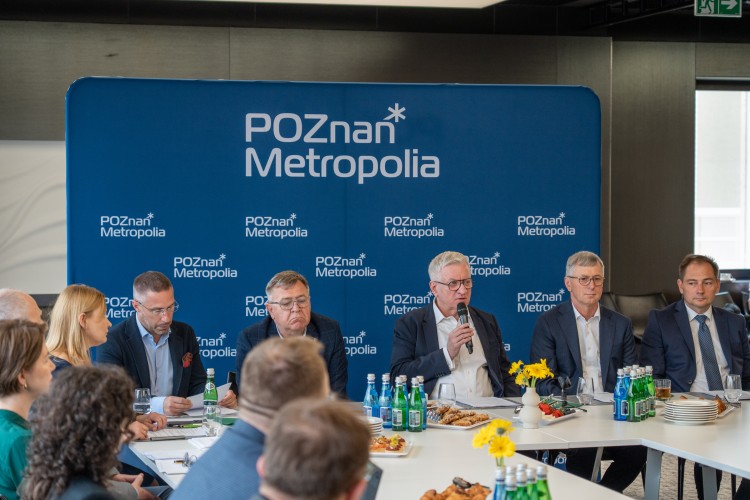 Zdjęcie przedstawia kilka osób siedzących obok siebie (włodarze gmin i miast Metropolii Poznań).