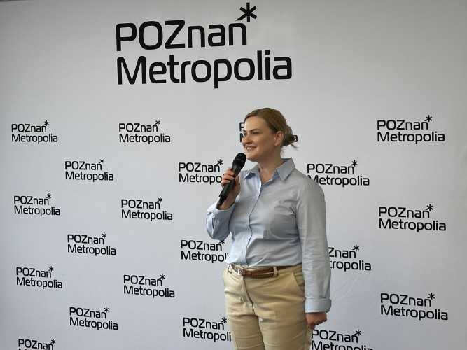 Zdjęcie przedstawia kobietę z mikrofonem w ręce (dyrektorka Metropolii Poznań).