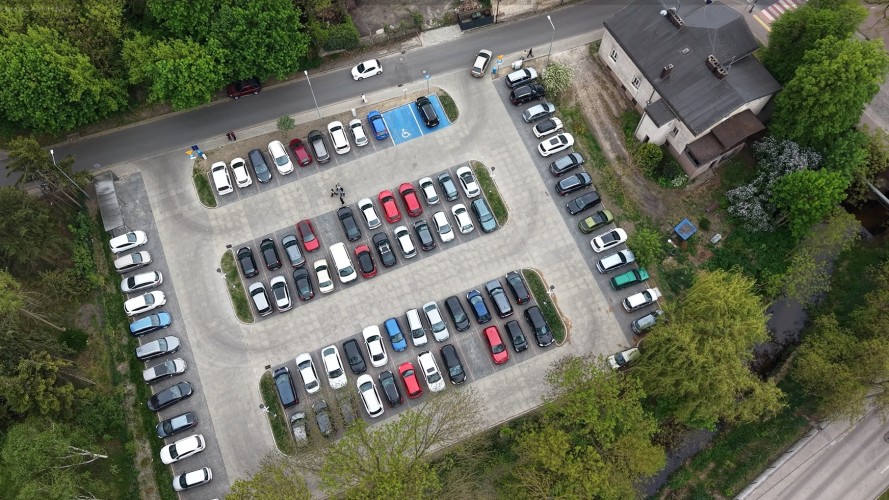 Zdjęcie z dronu przedstawiające parking samochodowy w Szamotułach.
