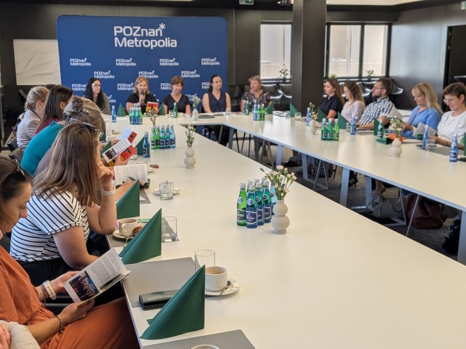 Zdjęcie przedstawia ludzi siedzących przy stole.